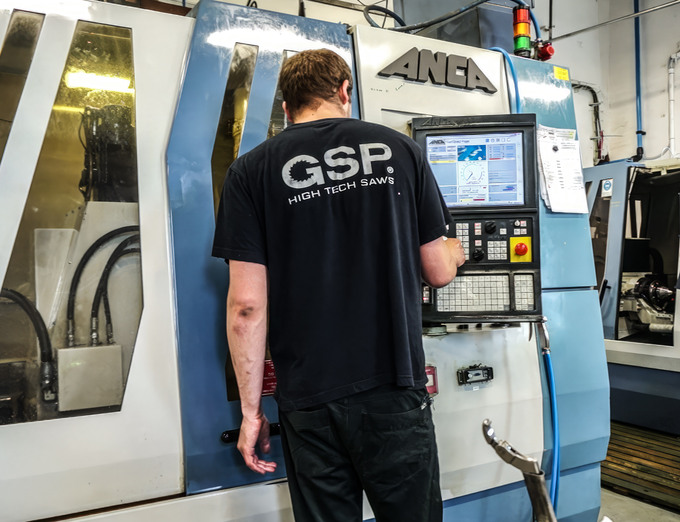 Worker grinding a blade blank to refine its surface
